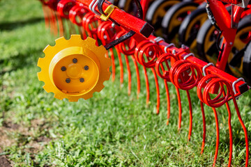 Fototapeta premium Red agriculture farming tractor for soil recurment close up of red parts of tractor
