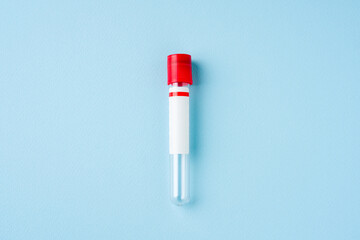 Top view of test tube with red cap on blue background