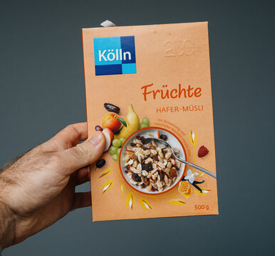 Paris, France - Mar 11, 2020: A hand holding a box of Kolln Fruchte Hafer-Musli, featuring fruit and oat ingredients, promoting a nutritious breakfast option.