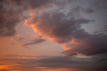 An enchanting sky captured at dusk, showcasing a palette of pink, orange and blue hues with soft clouds 