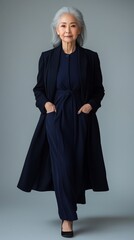 Naklejka premium Graceful Elderly Asian Woman in Sophisticated Outfit, Projecting Confidence and Heritage Against an Isolated Background, Highlighting Cultural Diversity