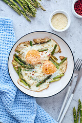 Fried eggs with asparagus and grated cheese. Breakfast concept.