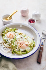 Breakfast with fried egg in zucchini noodles nest with feta cheese, healthy breakfast, close up