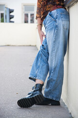 closeup of young woman wearing a large blue jeans  trousers in the street