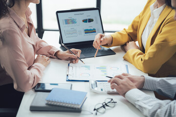 Business Strategy Meeting: A diverse team of professionals,  engaged in a collaborative discussion,  analyzing data and charts on a tablet and documents.