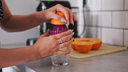 Girl Makes Orange Juice Close-Up In Kitchen