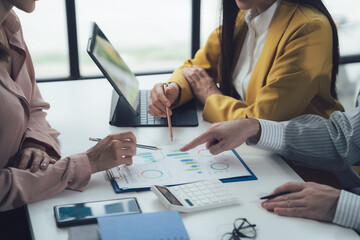 Business Professionals Analyzing Data: A team of diverse business professionals collaborate and...