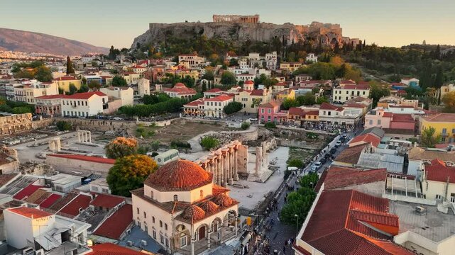 Stunning aerial view of Monastiraki Square in Athens, captured at sunset. Flying over vibrant city center, with the Acropolis in the background. Athens - popular tourist destination