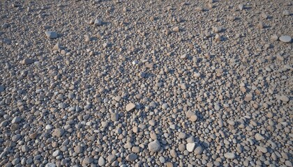 Natural pebbles texture on sandy beach, outdoor landscape, copy space
