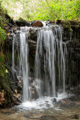 beautiful horizontal photo of a waterfall with lush green forest in the background