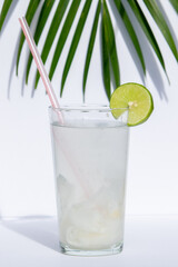 Fresh Coconut Beverage with Lemon Accent on White Background
