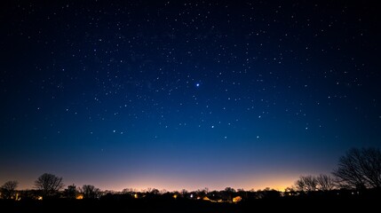 A serene night sky filled with stars, showcasing a tranquil landscape and distant lights.