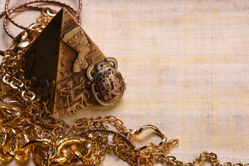 Egyptian pyramid, scarab and ancient golden jewelry treasure concept background.