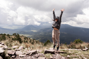 Young woman celebrates hiking achievement in scenic Cumbres del Ajusco