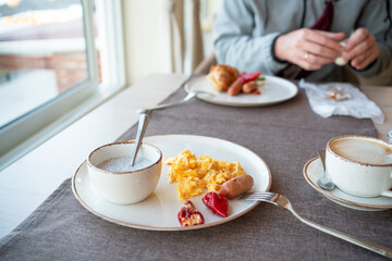 Breakfast in the hotel. Plate with omelet, sausage, pepper and yogurt with chia seeds