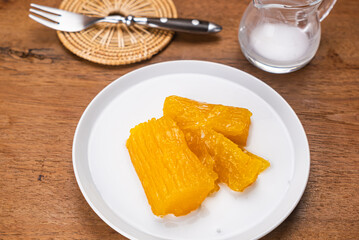 Cassava in syrup. High angle view of delicious homemade cassava or tapioca in syrup in white ceramic dish on wooden table.