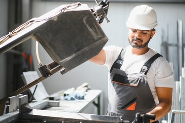 Portrait of cheerful young worker wearing hardhat at modern factory