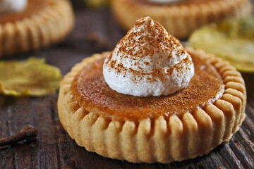 Mini pumpkin pies on a wooden background. Selective focus.