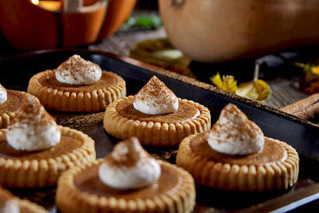 Mini pumpkin pies on a wooden background. Selective focus.