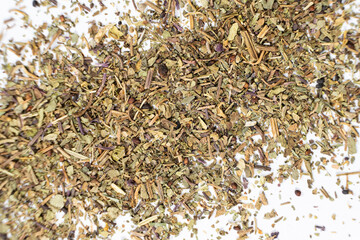 Dry basil spice seasoning macro texture on white background.