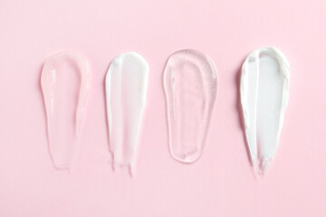 Smears of different cosmetic products on pink background, flat lay