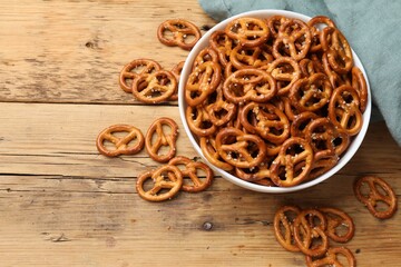 Delicious pretzel crackers on wooden table, flat lay