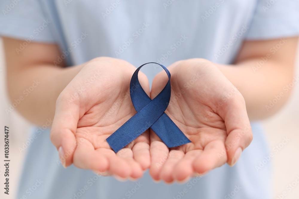 Canvas Prints Woman with dark blue ribbon on light background, closeup. Arthritis disease and colon cancer awareness