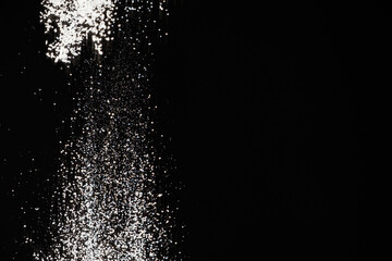 Abstract black and white background of pouring flour, space for text
