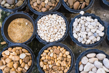 Aerial View of Various Natural Stone and Sand Materials Neatly Organized in Black Buckets for Landscaping Design