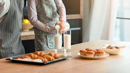 Little Girl Having Snacks With Dad In Kitchen, Pouring Milk To Glasses, Tasting Freshly Baked Pastry, Having A Bite, Enjoying Homemade Food, Having Fun At Home Together, Wearing Aprons, Free Space