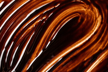 Wavy texture of melted chocolate with glossy highlights
