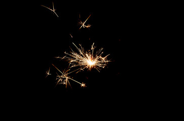 Sparklers sparkle brightly against a black background, creating the effect of magic and...
