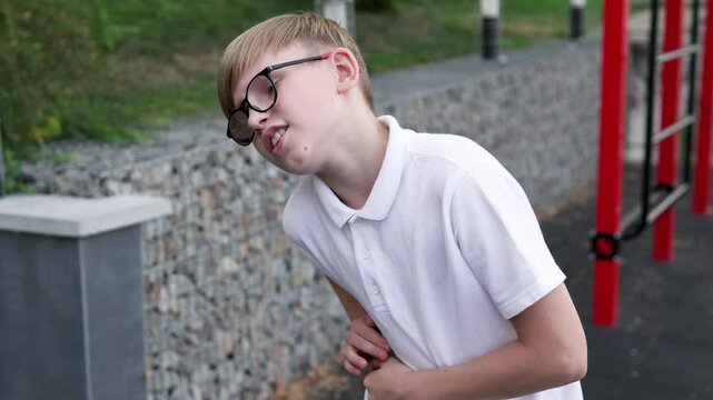 Teenager feels sharp pain in liver area during outdoor training. Concept of sports and injuries.