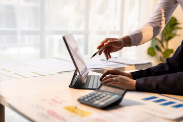 A man is pointing at a laptop screen while a woman looks on