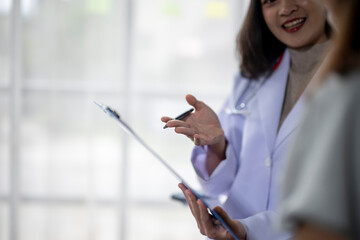 Female doctor is holding a clipboard and explaining treatment to a patient