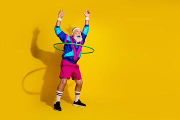 Full length photo of funny aged sportsman hula hoop empty space retro uniform isolated on yellow...