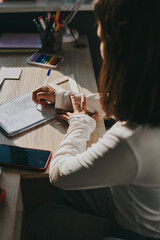 Schoolgirl at home schooling. The girl sits at the table with textbooks doing homework