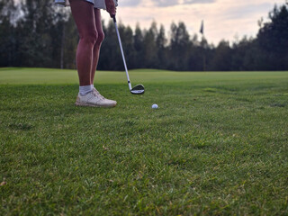 A golfer prepares to swing at a ball