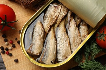 Tasty sprats in tin can served on table, flat lay