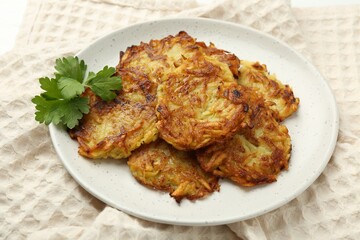 Delicious potato pancakes and parsley on table, closeup