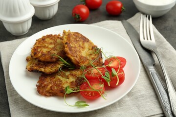 Delicious potato pancakes served on grey table, closeup