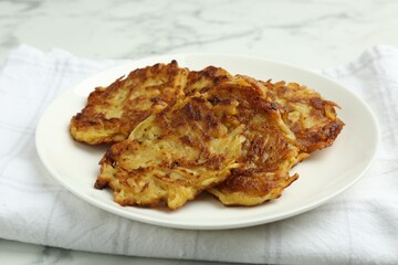 Delicious potato pancakes on white marble table, closeup