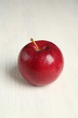 Fresh ripe red apple on white wooden table, closeup