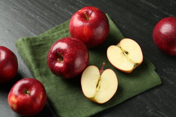 Whole and cut ripe red apples on grey textured table