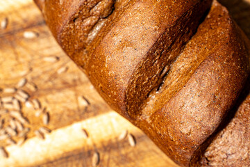 Pears stewed in red wine are poured with sauce on a black mica plate on a dark background.