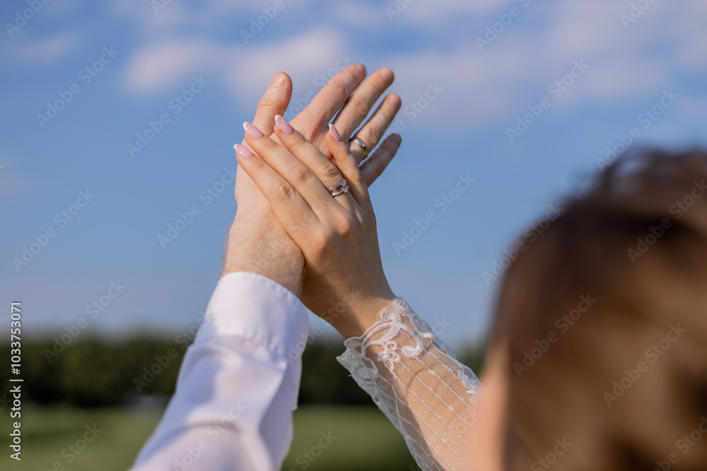 Wall mural the bride and groom together and wedding rings on their hands