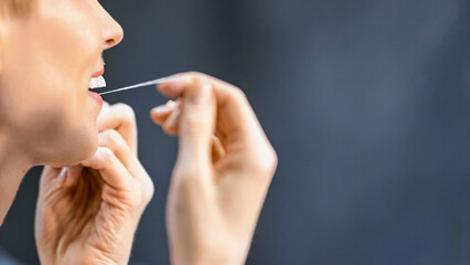 Obraz premium Toothcare. Unrecognizable Woman Flossing And Cleaning Teeth Preventing Cavity Doing Morning Routine In Bathroom. Empty Space