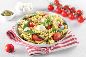 Italian cold salad with fusilli pasta, cherry tomatoes, mozzarella, arugula.
