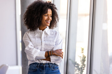 Confident Woman Standing by Window in Casual Outfit