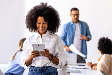 Happy Businesswoman Using Tablet in Modern Office Setting